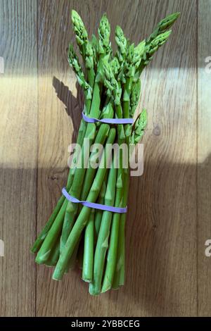 Still life view from above vibrant green asparagus bunch on wooden background Stock Photo
