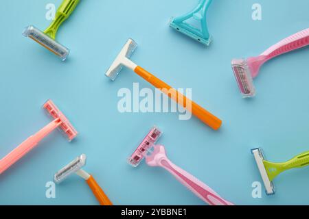 Many women razors on the blue background. Top view Stock Photo