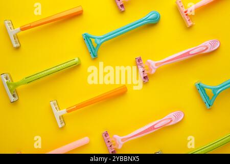 many women razors on the yellow background. Top view Stock Photo