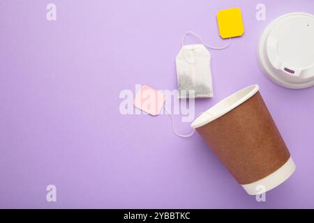 Disposable takeaway cups with tea bag on purple background, including clipping path. Top view Stock Photo