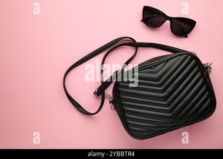 Women's Fashion Accessories. Black bag and sunglasses on pink background. Top view Stock Photo