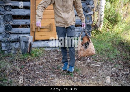 Man with firewood in basket Stock Photo