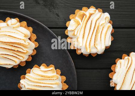 Appetizing lemon cupcakes with white cream on dark background. Holiday, surprise, birthday, Valentine's Day. Top view. Stock Photo