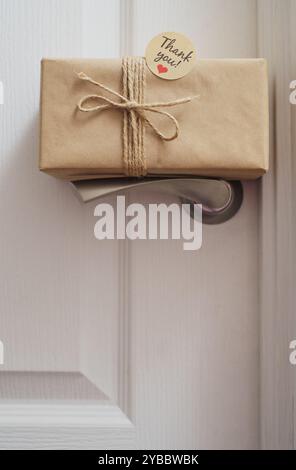 Gift box with Thank you sticker placed on the door handle Stock Photo