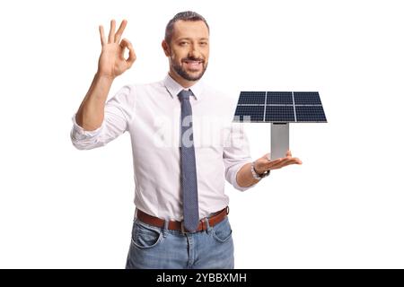 Professional man holding a small solar panel model and gesturing ok sign isolated on white background Stock Photo