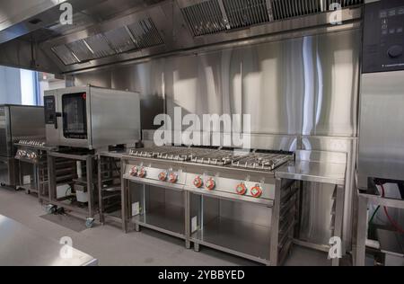 Stainless steel over in commercial kitchen Stock Photo