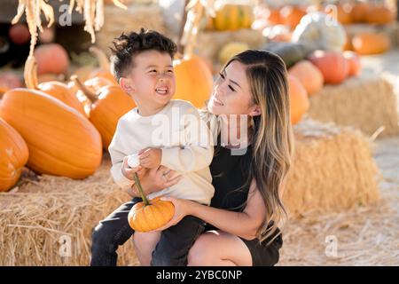Mother and son laughing together in a pumpkin patch Stock Photo