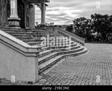 Concrete Curved Staircase Leading to Wooden Brown Door: Part of Macedonian Orthodox Church Architecture with Pillars, Cloudy Sky, Overcast Day Stock Photo