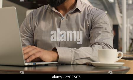 Close-up unrecognizable man guy typing on laptop businessman freelancer programmer working remote on internet using computer application in cafe make Stock Photo