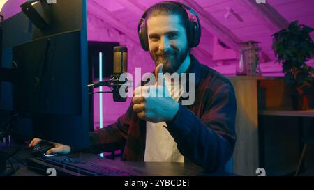 Happy Caucasian gamer man typing keyboard addict blogger male guy holding mouse playing online videogame at home positive player influencer showing Stock Photo