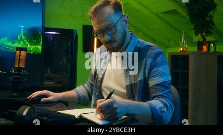 Focused serious Caucasian man freelancer male modern guy working writing results programmer crypto analyst typing keyboard computer pc concentration e Stock Photo