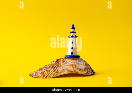 Close up of white miniature lighthouse on a seashell, sea and travel concept Stock Photo