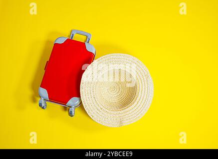 top view miniature red luggage lying on yellow background miniature travel concept Stock Photo