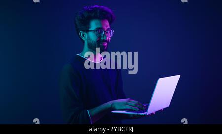 Arabian Indian man guy male programmer coder employer freelancer working using internet computer developer businessman business guy gamer hold laptop Stock Photo