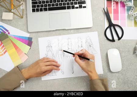 Fashion designer drawing sketch of stylish clothes at gray textured table, top view Stock Photo