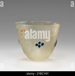 Beaker or Lamp, 4th-5th century A.D.  Additional Info: Free-blown vessel of pale green glass.  The vessel is conical in shape with a wide mouth.  It is sparsely decorated with shallow blobs of blue glass: on opposite sides is a pair of large blobs; on the other opposite sides is a pair of four small blobs arranged in a cross.  There is some discoloration due to weathering and slight iridescence. Stock Photo