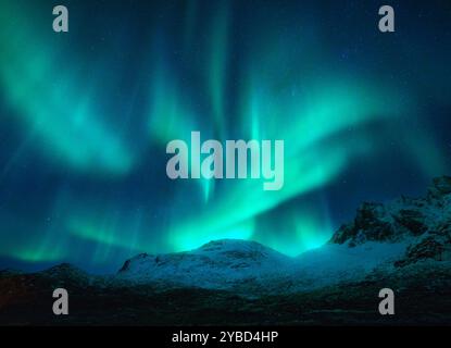 Northern lights over the snowy mountains at night in Norway Stock Photo ...