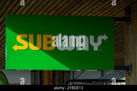 A vibrant green sign prominently features the Subway logo in a modern eatery, illuminated by natural light, inviting visitors inside for a meal Stock Photo