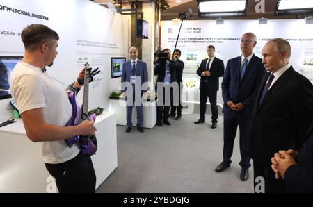 Moscow, Russia. 18th Oct, 2024. Russian President Vladimir Putin, right, accompanied by Russian Direct Investment Fund CEO Kirill Dmitriev, center, tours an exhibition showcasing cooperation between Russia and BRICS countries at the International Trade Centre, October 18, 2024 in Moscow, Russia. Credit: Gavriil Grigorov/Kremlin Pool/Alamy Live News Stock Photo