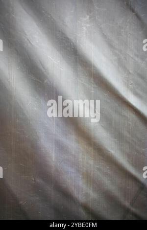 This image presents a detailed closeup of a piece of cloth set against a soft gray background, showcasing its intricate textures and qualities Stock Photo