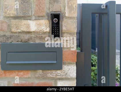 Modern mailbox and video intercom on brick wall Stock Photo