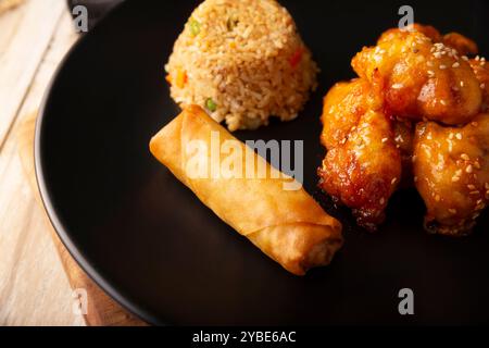 Sweet and sour chicken with fried rice and crispy spring roll, American Chinese food made out of fried, battered chicken covered with sauce. Tasty dis Stock Photo