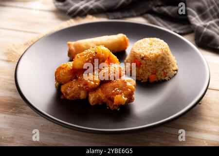 Sweet and sour chicken with fried rice and crispy spring roll, American Chinese food made out of fried, battered chicken covered with sauce. Tasty dis Stock Photo