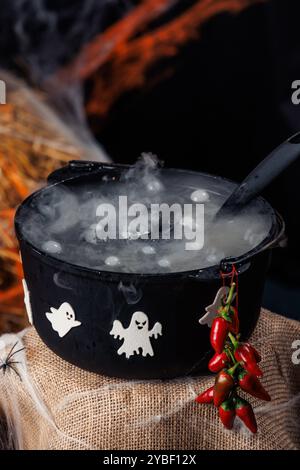 Cauldron, ghosts, spiders, web. Photo zone for Halloween, decorations and props, autumn holiday. Stock Photo