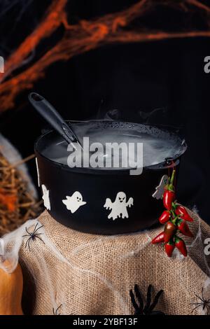 Cauldron, ghosts, spiders, web. Photo zone for Halloween, decorations and props, autumn holiday. Stock Photo