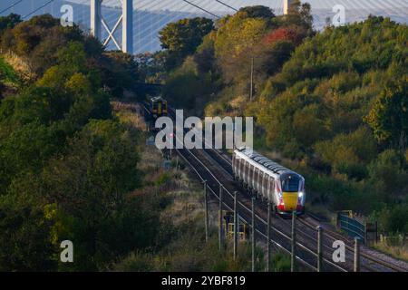 With The Forth Bridge & Queensferry Crossing In The Background A LNER Azuma Train Travels Between Dalmeny And Edinburgh Gateway Stations, Scotland, UK Stock Photo