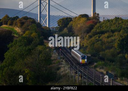 With The Forth Bridge & Queensferry Crossing In The Background A LNER Azuma Train Travels Between Dalmeny And Edinburgh Gateway Stations, Scotland, UK Stock Photo