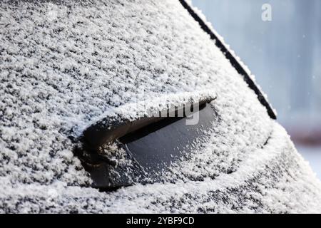 Close-up photo of a car wiper on rear window of modern SUV car covered with snow Stock Photo