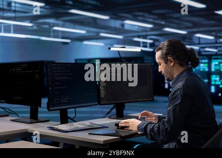Admin working on computer to check for signs of imminent failure in data center infrastructure. IT expert working at PC desk to prevent damages in server hub, monitoring critical systems Stock Photo