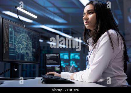 Admin working on PC in data center with artificial intelligence technology to process massive datasets. Worker solving tasks in server hub storing data used for deep learning Stock Photo