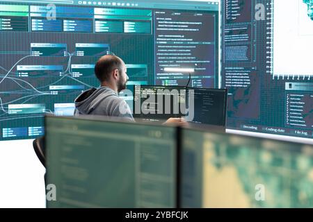 Governmental hackers analyzing cyber threats on big screens, managing important database hacking activity in high tech agency office. Work on cyber defense to protect national security. Stock Photo