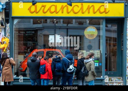 Tourists in front of Arancina, an Italian street food takeaway restaurant in Notting Hill. London, England, United Kingdom Stock Photo
