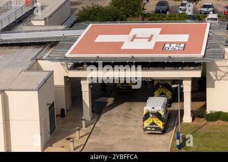 Monroe, Louisiana, USA - April 4, 2024: An ambulance pulls into a hospital Medical center, underneath a medical helipad. Stock Photo