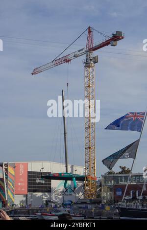 Barcelona, Spain; Oct 12 24: Crane lowering the Taihoro AC75 ship on land to perform maintenance between America's Cup regattas. Hydrofoils are seen. Stock Photo