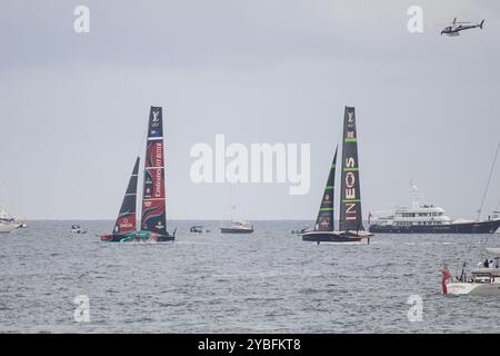 Barcelona, Spain; Oct 12 24: Emirates New Zealand and Ineos Britannia ships racing suspended on hydrofoils during the America's Cup. Helicopter hovers Stock Photo