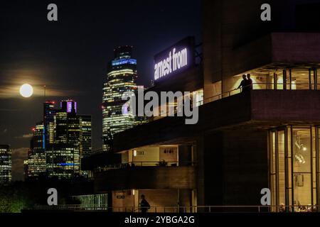 London, UK. 18th October 2024. Patrons at the National Theatre enjoy a moonlit scene during a performance interval as a waning Hunter's supermoon rises on Friday evening against the City skyline. A supermoon occurs when the earth's satellite is closer than usual, and this month is the brightest of the four scheduled this year. Credit: Eleventh Hour Photography/Ģ����ý Live News Stock Photo