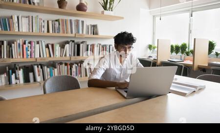 Serious Indian student man studying in public library Stock Photo