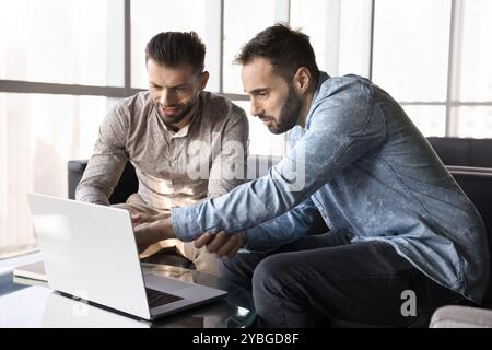 Two engaged businessmen using laptop in co-working together Stock Photo