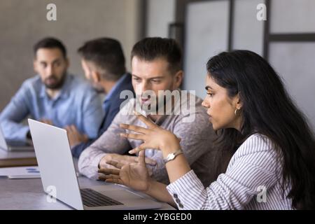 Two focused multiethnic business professional colleagues discussing online project Stock Photo