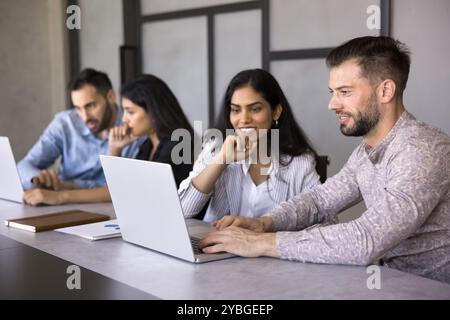 Positive diverse couple of office colleagues engaged in online presentation Stock Photo