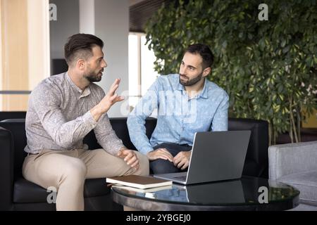 Two business partners discussing work project at laptop Stock Photo