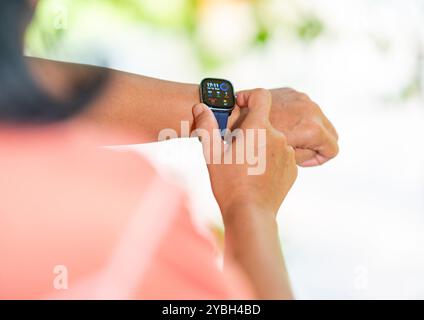 Woman Checking Her Pulse After Exercise on blur background. Stock Photo