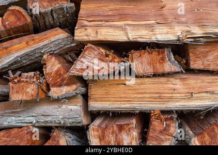 Bundle of split reddish logs sold as firewood. Ways to store firewood outdoors Stock Photo