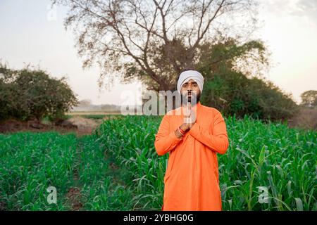 Indian farmer, young, standing on an agricultural field Stock Photo