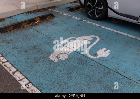 Car park with signage designated for EV cars at charging station. Stock Photo