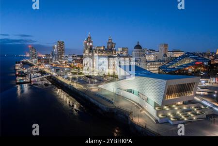 Liverpool waterfront from above at night, showing the illuminated Pier Head and city skyline beside the River Mersey. Stock Photo